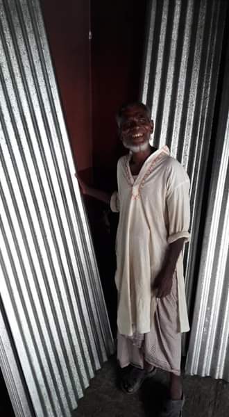 Corrugated iron and smiling man.